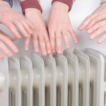 Family warming up hands over electric heater